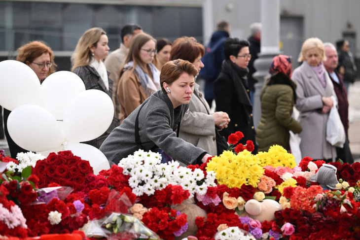 Người dân đặt hoa tưởng niệm bên ngoài nhà hát Crocus City Hall ở ngoại ô Matxcơva, Nga, ngày 26-3 - Ảnh: AFP