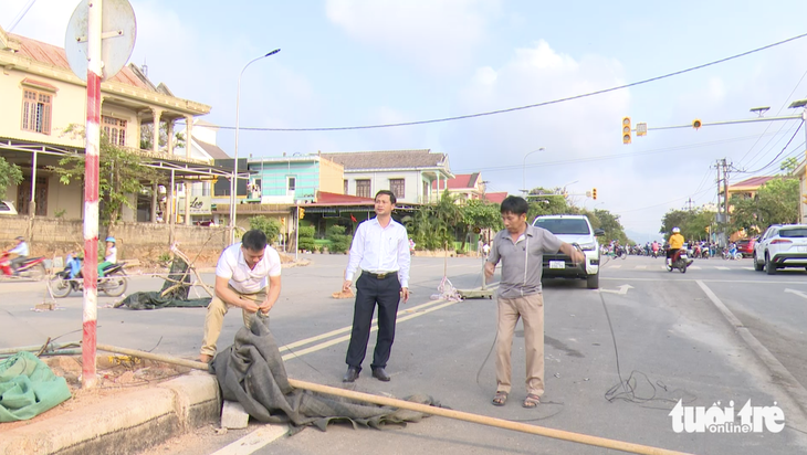 Người dân tháo dỡ các vật cản rào đường Hùng Vương sau khi được chủ tịch UBND huyện Hướng Hóa vận động - Ảnh: HOÀNG TÁO