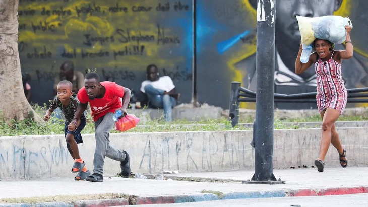 Người dân hoảng sợ khi nghe thấy tiếng súng ở gần Cung điện Quốc gia tại thủ đô Port-au-Prince của Haiti hôm 21-3. Đất nước này đã chìm trong bạo lực suốt những ngày qua và chưa có dấu hiệu sớm ổn định trở lại. (Reuters/Ralph Tedy Erol)