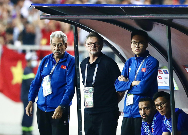 HLV Troussier và trợ lý ngôn ngữ Hoàng Bách (bìa phải, đứng) trong một trận đấu của đội tuyển Việt Nam - Ảnh: HOÀNG TÙNG