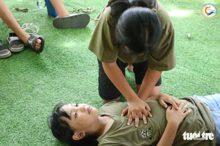 Các bạn nhỏ ở Học viện Con Rồng Cháu Tiên thực hành kỹ năng sơ cấp cứu  - Ảnh: LÊ VĂN QUANG