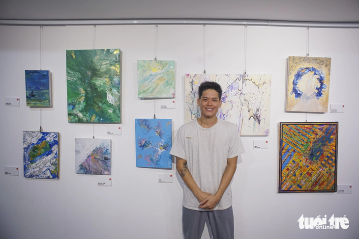 John Huy Trần bên các bức vẽ của mình trong hành trình chống trầm cảm 