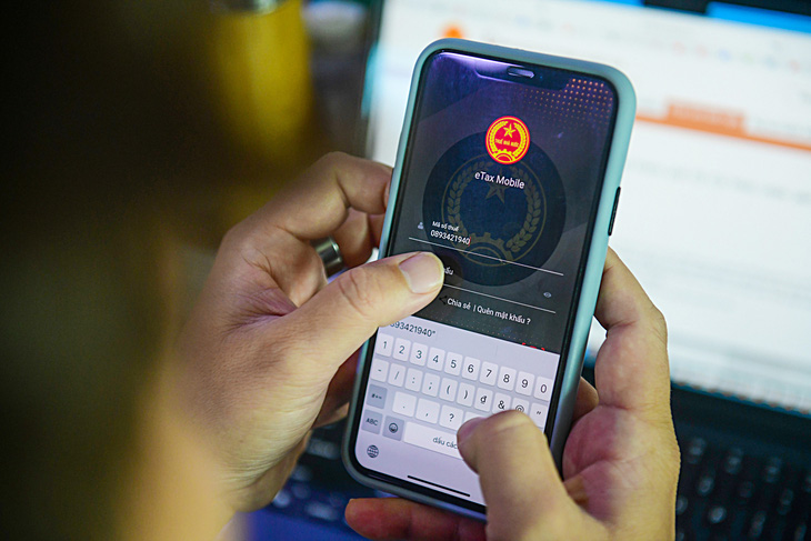 Khách hàng thao tác với App eTax Mobile - Ảnh: QUANG ĐỊNH