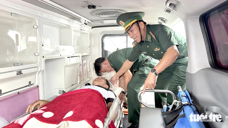Khi người dân bị thương, những người lính biên phòng sơ cứu rồi đưa đi cấp cứu - Ảnh: TRẦN MAI