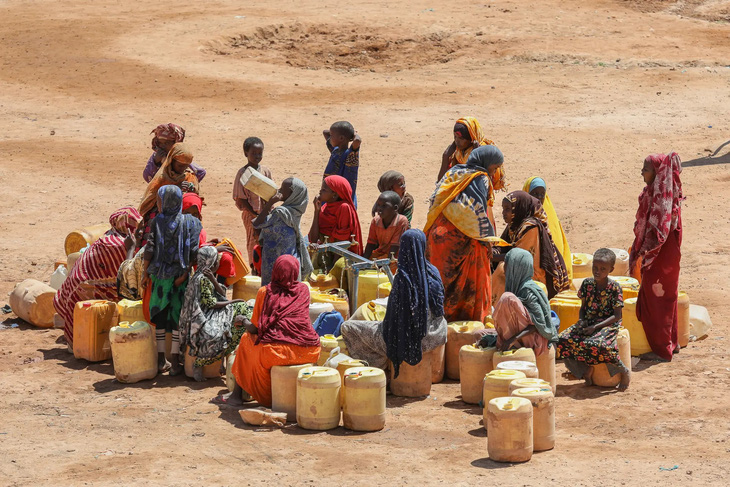 Một nhóm phụ nữ và trẻ em đang tập trung đợi lấy nước ở một khu trại trú tạm tại Ladan, Somalia. Họ đã buộc phải rời bỏ nhà cửa vì biến đổi khí hậu và tình trạng không an toàn - Ảnh: EPA