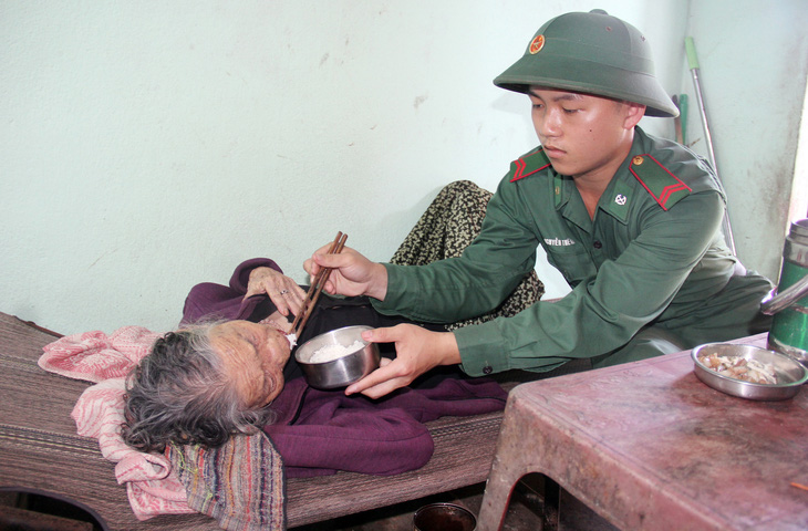 Ngày nào cũng vậy, những người lính biên phòng chăm sóc từng tí cho cụ Nguyễn Thị Diên (97 tuổi, thôn An Cường, xã Bình Hải, huyện Bình Sơn) - Ảnh: TRẦN MAI