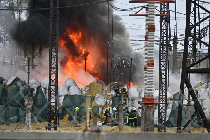 Lực lượng Ukraine dập lửa tại một trạm biến áp ở Kharkov bị trúng tên lửa của Nga vào ngày 22-3 - Ảnh: AFP