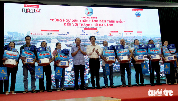Nguyên Phó thủ tướng thường trực Trương Hòa Bình và ông Trần Chí Cường, phó chủ tịch UBND TP Đà Nẵng, trao quà cho ngư dân - Ảnh: TRƯỜNG TRUNG