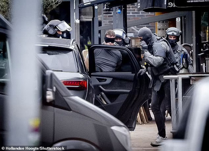 Một người đàn ông bị bắt và đưa vào ô tô ở Ede, Hà Lan - Ảnh: SHUTTERSTOCK
