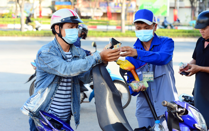 Người dân đổ xăng trên đường Điện Biên Phủ, quận Bình Thạnh, TP.HCM vào chiều 29-3  - Ảnh: QUANG ĐỊNH