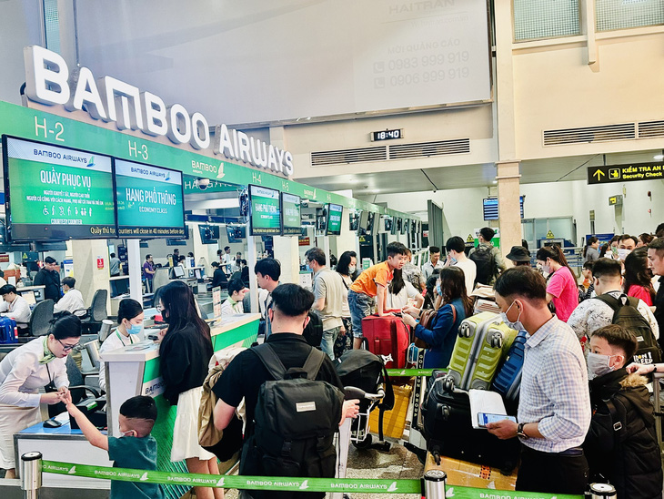 Bamboo Airways sử dụng một phần nhân lực dôi dư do giảm quy mô tàu bay là các tiếp viên hàng không để làm thủ tục check-in tại Tân Sơn Nhất - Ảnh: CÔNG TRUNG