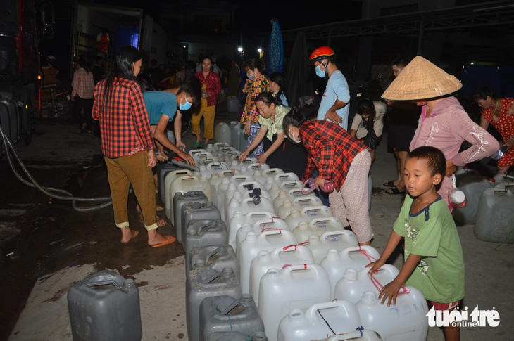 Giữa đêm khuya, hàng chục người dân tập trung tại các vòi nước công cộng để hứng về sử dụng - Ảnh: MẬU TRƯỜNG