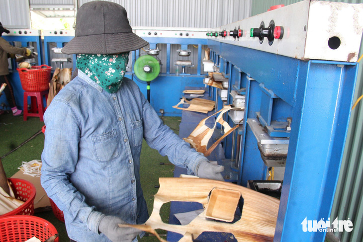 Công nhân dùng máy nén nhiệt độ cao để sản xuất các vật dụng từ mo cau