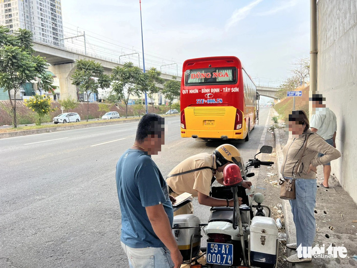 Một nhà xe bị Đội cảnh sát giao thông Rạch Chiếc lập biên bản lỗi dừng xe nơi có biển báo cấm - Ảnh: MINH HÒA