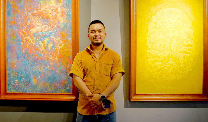 Họa sĩ trẻ Nguyễn Thanh Vũ bên tác phẩm tại triển lãm Từ tính tứ linh  - Ảnh: H.VY