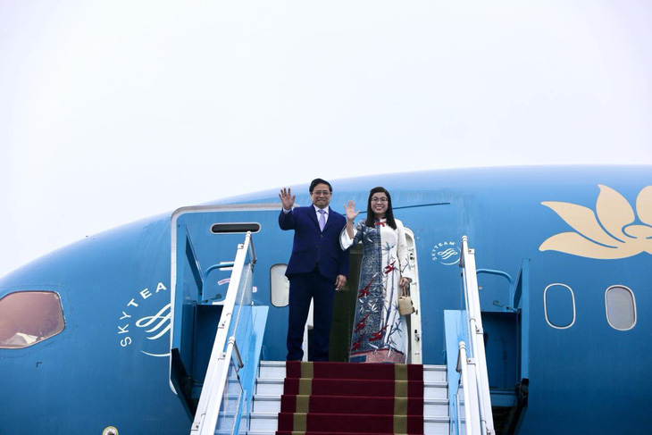Thủ tướng Phạm Minh Chính và phu nhân vẫy tay chào khi lên chuyên cơ - Ảnh: DUY LINH