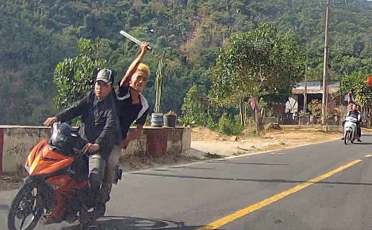 Thanh niên ngồi sau xe máy vung mã tấu chém vào ô tô đi ngược chiều trên quốc lộ 55, huyện Hàm Thuận Bắc, Bình Thuận - Ảnh cắt từ camera hành trình