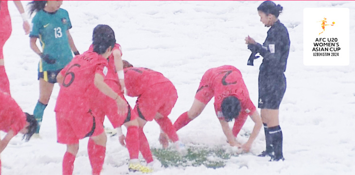 Nữ cầu thủ Hàn Quốc dùng tay cào tuyết để đặt bóng thực hiện cú đá phạt - Nguồn: X