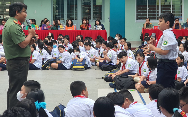 Thiếu tá Võ Công Nghiệp (cán bộ đội an ninh Công an quận Tân Bình, TP.HCM) đặt câu hỏi cho học sinh về thuốc lá điện tử - Ảnh: H.HG