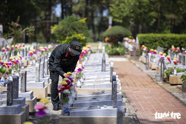 Cán bộ công an thắp hương khu mộ liệt sĩ TP Hà Nội - Ảnh: HOÀNG TÁO