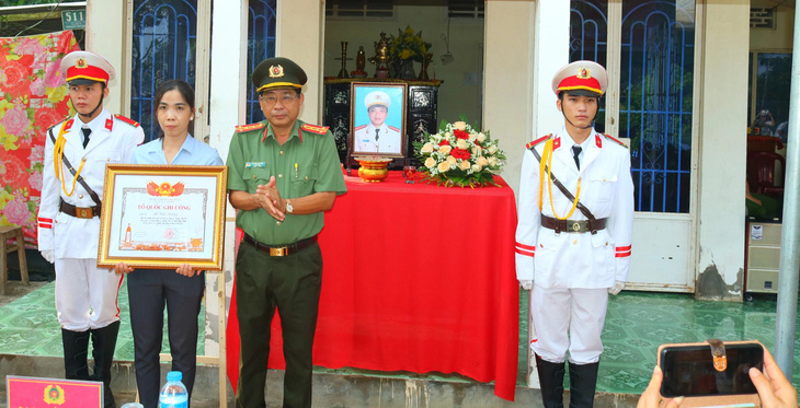 Giám đốc Công an tỉnh Đồng Tháp trao bằng Tổ quốc ghi công cho đại diện gia đình liệt sĩ Hồ Tấn Dương - Ảnh: ĐẶNG TUYẾT