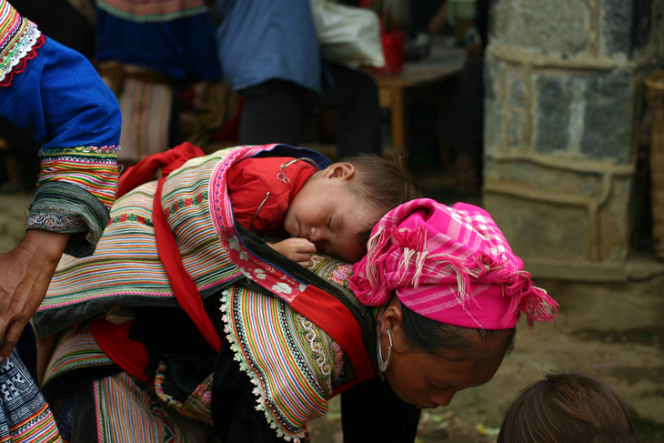 Tác phẩm Trên lưng mẹ, chụp em bé dân tộc Mông ngủ ngon trên lưng của người mẹ đang bán hàng tại góc bán rượu phiên chợ Bắc Hà