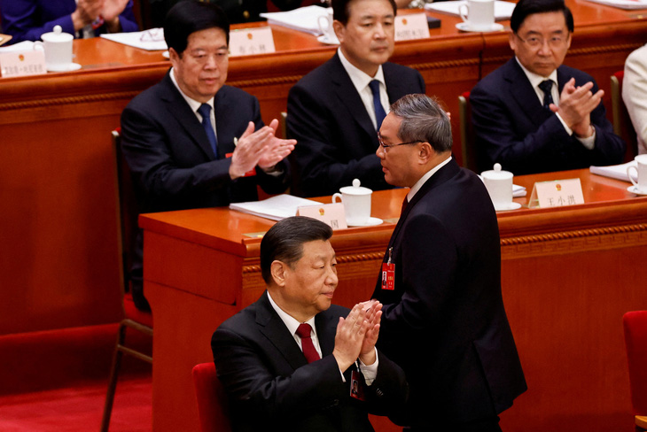 Chủ tịch Trung Quốc Tập Cận Bình vỗ tay trong phiên khai mạc kỳ họp Đại hội đại biểu nhân dân toàn quốc (tức Quốc hội) Trung Quốc khóa 14 ngày 5-3. Còn Thủ tướng Lý Cường lên đọc báo cáo công tác - Ảnh: REUTERS
