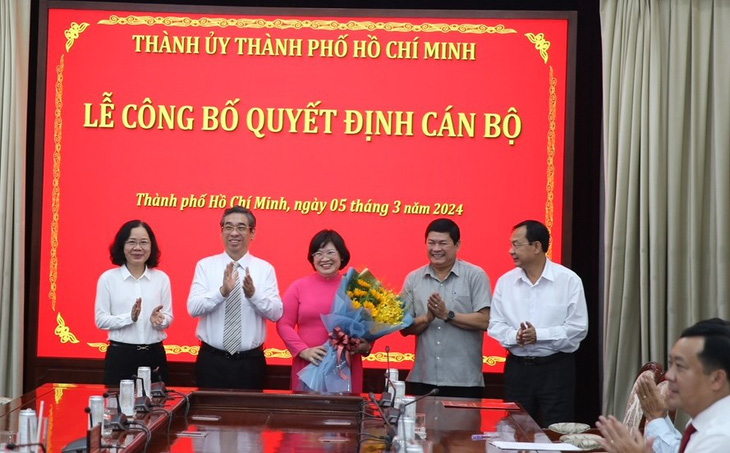 Phó bí thư Thành ủy TP.HCM Nguyễn Phước Lộc (thứ hai từ trái qua) cùng lãnh đạo Ban Tổ chức Thành ủy TP tặng hoa chúc mừng bà Văn Thị Bạch Tuyết - Ảnh: TIẾN LONG