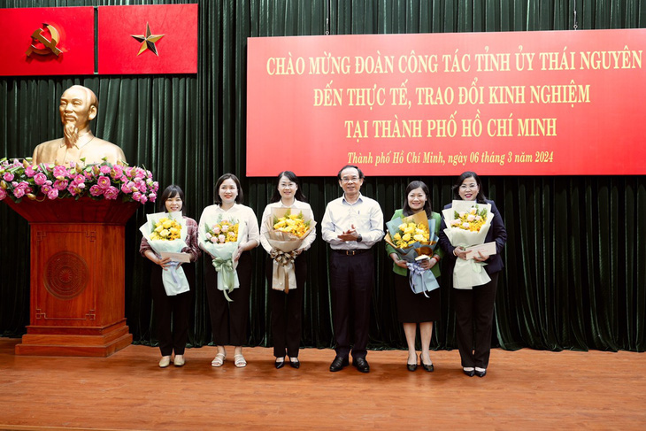 Bí thư Thành ủy TP.HCM Nguyễn Văn Nên trao hoa chúc mừng các các cán bộ nữ trong đoàn công tác nhân Ngày Quốc tế phụ nữ 8-3 - Ảnh: HỮU HẠNH