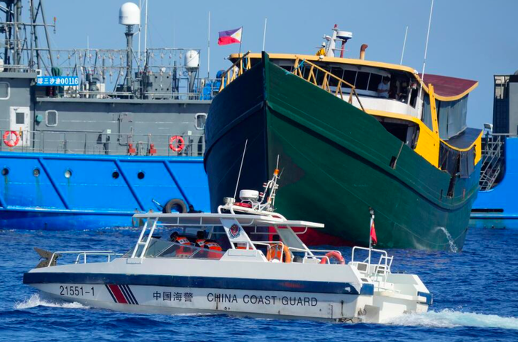 Một tàu nhỏ của hải cảnh Trung Quốc di chuyển gần tàu tiếp tế UM4 (màu xanh) của Philippines sau khi tàu tiếp tế này bị hải cảnh Trung Quốc phun vòi rồng ở Biển Đông hôm 5-3 - Ảnh chụp màn hình US NEWS