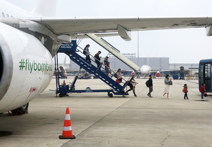 Hành khách xuống máy bay tại sân bay Tân Sơn Nhất ngày 5-3 - Ảnh: T.T.D