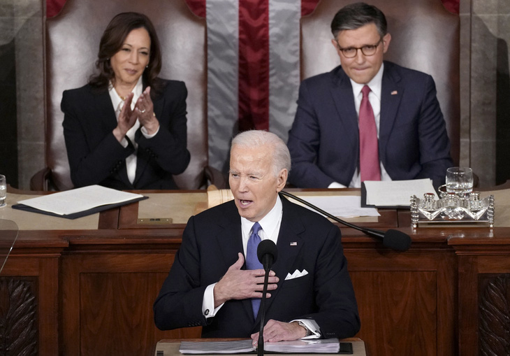 Tổng thống Mỹ Joe Biden đọc thông điệp liên bang trước sự ủng hộ của Phó tổng thống Kamala Harris (trái) và sự không thoải mái của Chủ tịch Hạ viện Mike Johnson (phải) - Ảnh: REUTERS