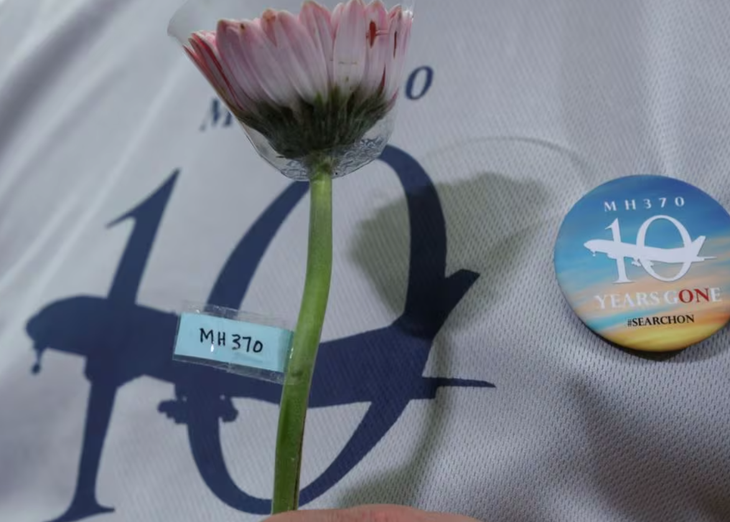 Người thân nạn nhân cầm hoa trong một buổi tưởng nhớ 10 năm máy bay MH370 mất tích ngày 3-3 - Ảnh: REUTERS