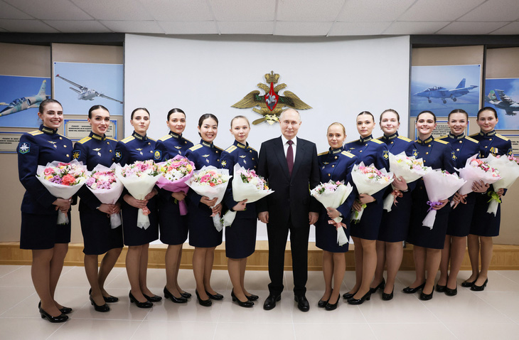 Tổng thống Nga Vladimir Putin chụp ảnh cùng các nữ sinh viên tốt nghiệp Trường Phi công Hàng không Quân sự cao cấp mang tên anh hùng Liên Xô A.K. Serov ở Krasnodar, Nga, ngày 7-3 - Ảnh: SPUTNIK
