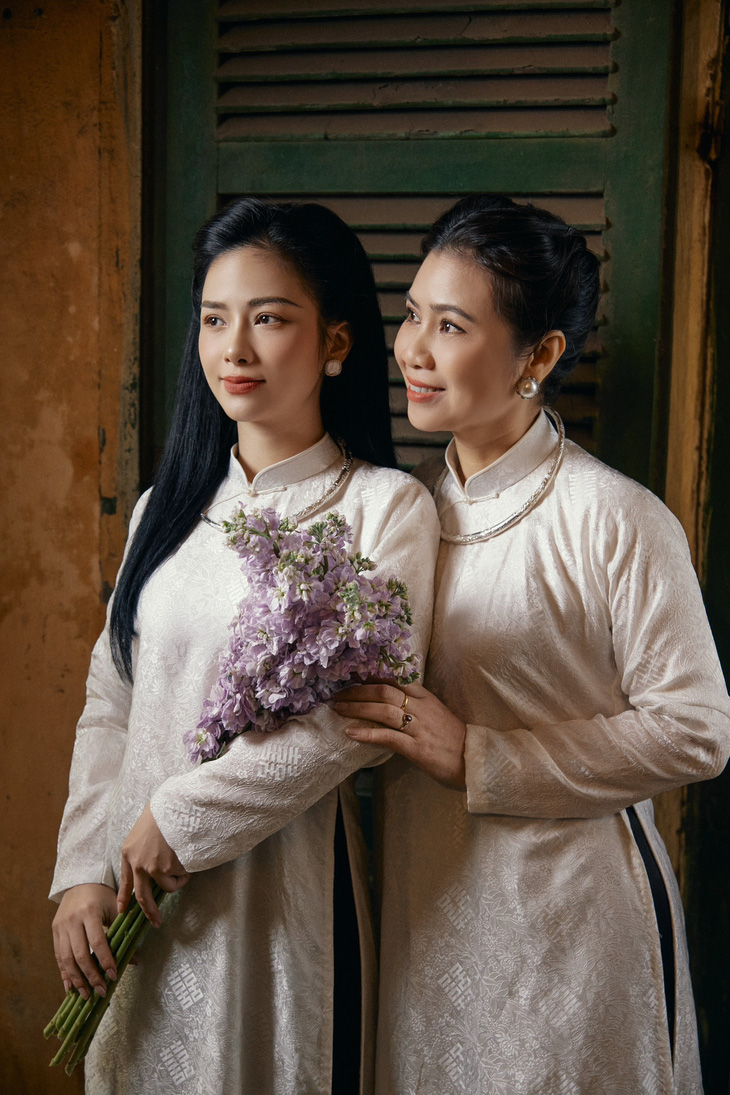 Trong loạt ảnh, mẹ con Dương Hoàng Yến cùng diện áo dài trắng, đeo kiềng bạc, và trang điểm làm tóc chuẩn cô gái Hà Nội.