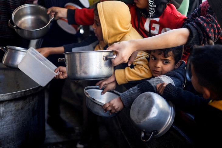Trẻ em và người dân Palestine chờ lấy đồ ăn tại một bếp cứu trợ ở Rafah, miền nam Gaza, ảnh chụp ngày 5-3 - Ảnh: REUTERS