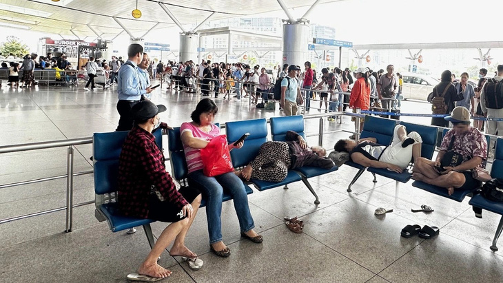 Hành khách nằm trên ghế ngồi ở nhà ga sân bay - Ảnh: D.T.C