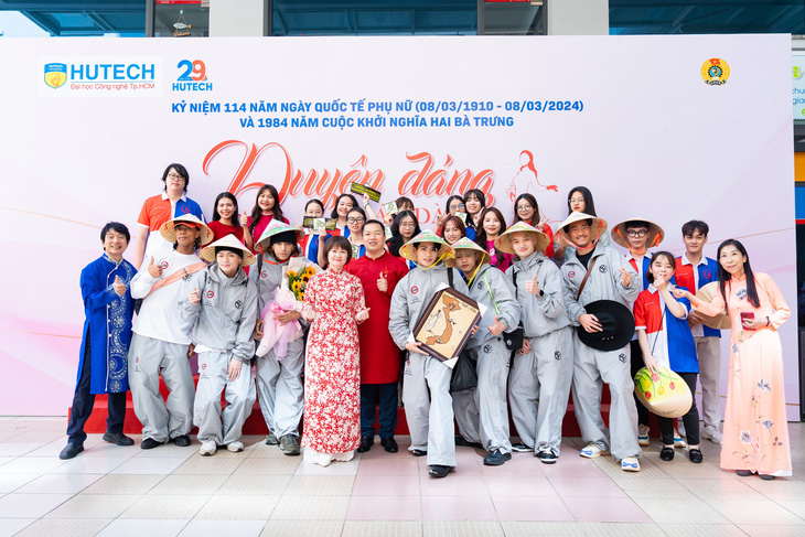 Hòa chung với không khí lễ hội chào mừng Ngày Quốc tế Phụ nữ 8-3, các thành viên của Psychic Fever đội nón lá, chụp hình chung với các thầy cô giáo (người Nhật và người Việt cùng mặc áo dài) và sinh viên