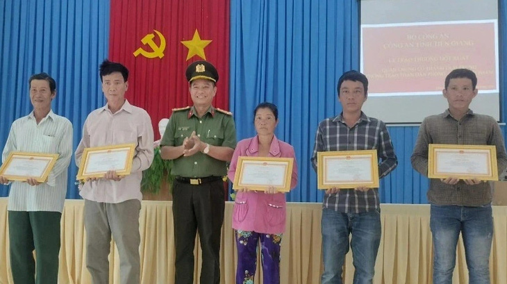 Đại tá Nguyễn Hồng Khắc, phó giám đốc Công an tỉnh Tiền Giang, trao giấy khen và tiền thưởng các cá nhân - Ảnh: LÊ HOÀI