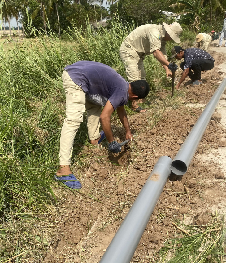 Lắp đường ống dẫn nước ngọt cho người dân vùng ảnh hưởng hạn mặn ở xã Tài Văn, huyện Trần Đề - Ảnh: KHẮC TÂM
