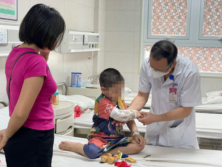 Bác sĩ Bệnh viện Sản nhi tỉnh Phú Thọ thăm khám cho bệnh nhi bị chó béc giê tấn công - Ảnh: BVCC