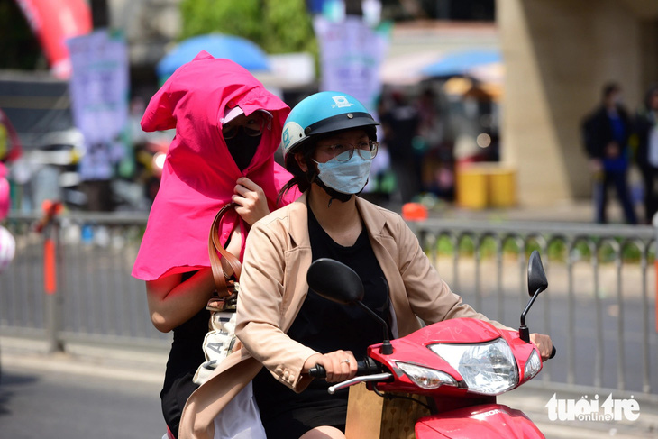 Nắng nóng oi bức, người dân TP.HCM tìm nhiều cách chống nắng khi đi ngoài đường - Ảnh: DUYÊN PHAN