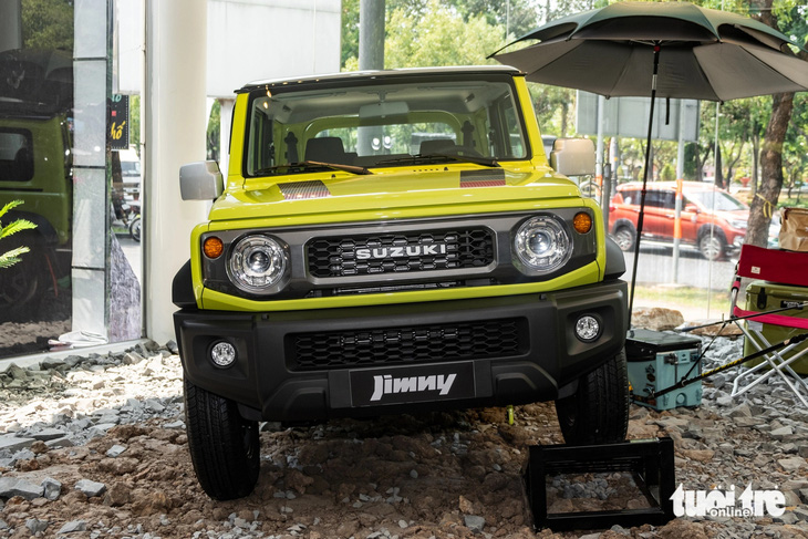 Suzuki Jimny thu hút sự chú ý đặc biệt của các hội nhóm chơi off-road và cắm trại. Thiết kế mang đậm phong cách retro hình hộp gợi nhớ đến các mẫu xe Land Rover Defender hay Mercedes-Benz G-Class. Trong sự kiện ra mắt xe, đại lý còn đặt chiếc Jimny trên nền gạch đá cùng một vài món phụ kiện dã ngoại như ghế, thùng đồ hay ô...