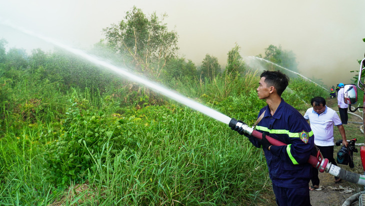 Lực lượng chức năng đang nỗ lực cắt đường băng để cản lửa - Ảnh: THANH HUYỀN