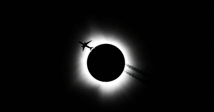 Một máy bay bay qua vùng trời tại Bloomington, bang Indiana (Mỹ) vào thời điểm nhật thực toàn phần ngày 8-4 - Ảnh: Bobby Goddin/USA Today Network