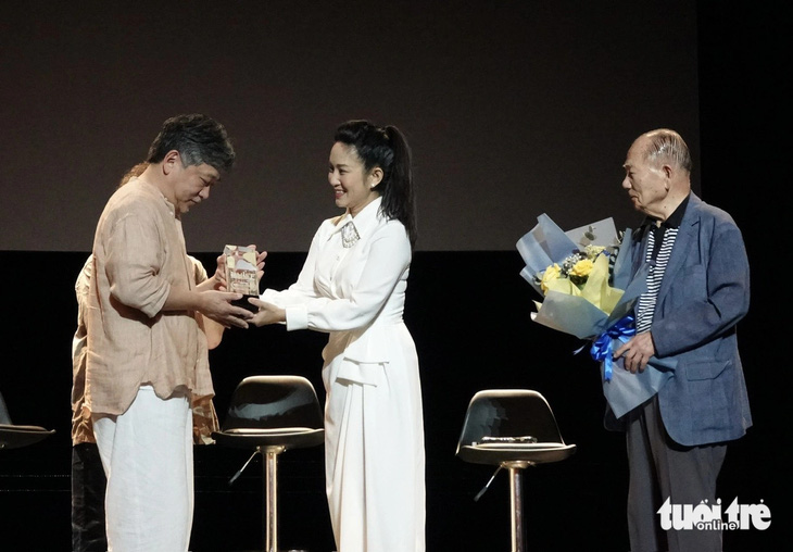 Đạo diễn Hirokazu Kore-eda nhận kỷ niệm chương của HIFF 2024 và hoa từ bà Nguyễn Thị Thanh Thúy, phó giám đốc Sở Văn hóa - Thể thao TP.HCM và ông Kim Dong Ho, chủ tịch danh dự HIFF 2024 - Ảnh: T.T.D.