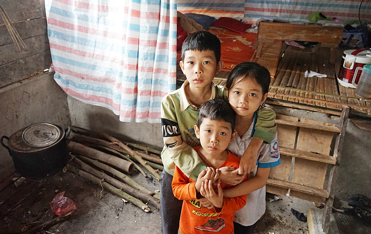 Ba đứa bé  Thành Long,  Ngọc Hoa, Minh Tân  đang sống nhờ  chuồng lợn cũ  của người bác - Ảnh: VŨ TUẤN