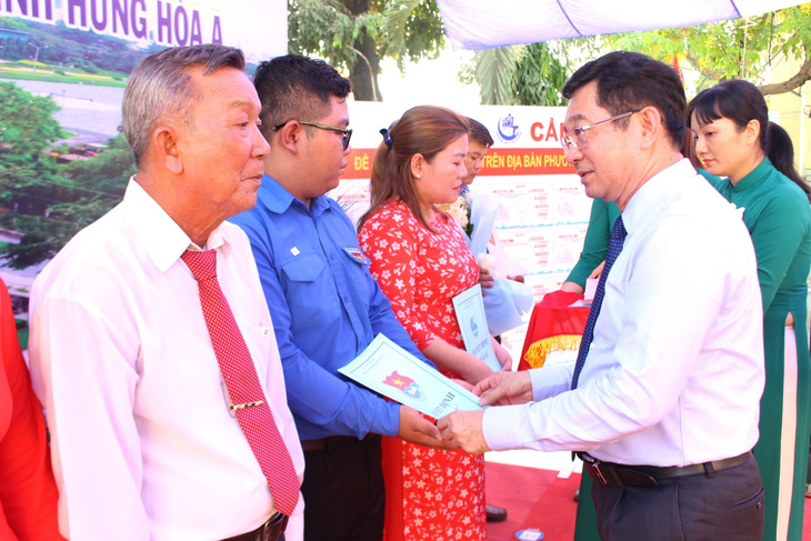 Chủ nhiệm Ủy ban Kiểm tra Thành ủy TP.HCM Dương Ngọc Hải trao các quyết định nhân sự cho ban điều hành khu phố mới - Ảnh: L. T.