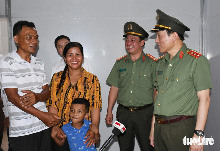 Thượng tướng Lương Tam Quang, thứ trưởng Bộ Công an (bìa phải), chúc mừng gia đình anh Thạch Sa Ruôl - Ảnh: HỒ GIANG