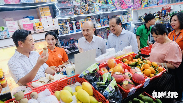 Khi biết các chủ tạp hóa có nhu cầu vay vốn, ông Nguyễn Văn Dũng - Phó Chủ tịch UBND TP.HCM (trái, ngoài cùng) gợi ý tìm hiểu về gói vay đối với hộ gia đình, nhằm phát triển hoạt động sản xuất và kinh doanh - Ảnh: BÔNG MAI 
